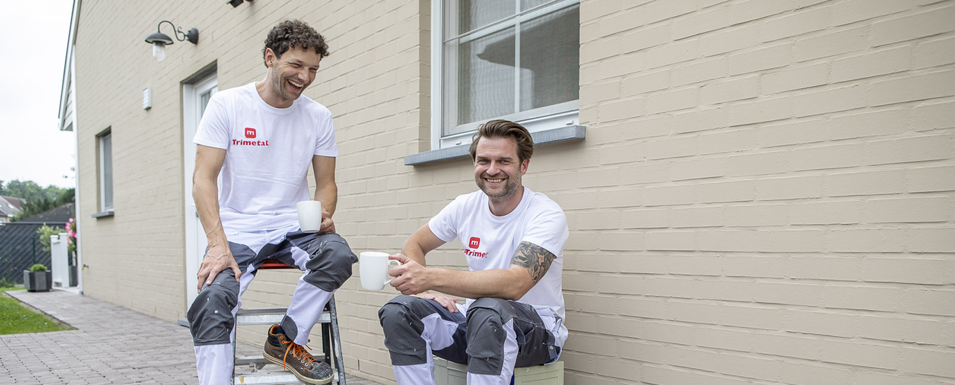 schilders tijdens koffiepauze bij buitengevel